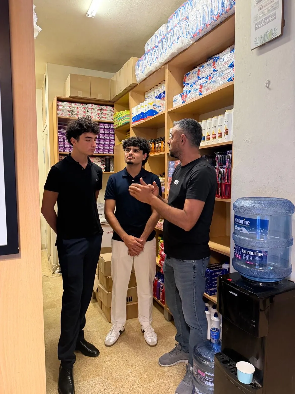 A Beit el Baraka team member points to a map and planning board while two students watch.